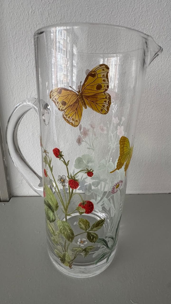 Jarra de vidrio con motivos florales y mariposas