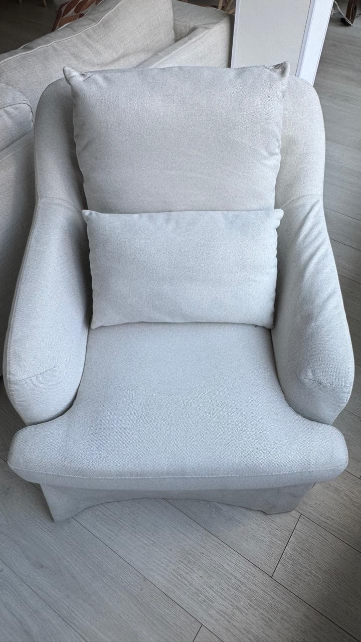 Sillón tapizado en tela color blanco roto con cojines